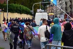 zdjęcie kolorowe: policjanci zabezpieczający trasę przemarszu idący z uczestnikami ulicami Katowic