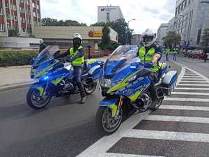 zdjęcie kolorowe: dwóch policjantów katowickiej drogówki na motocyklach służbowych zabezpieczających czoło przemarszu