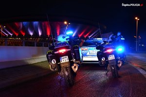 zdjęcie kolorowe: policyjny radiowóz i motocykle zaparkowane przed katowickim Spodkiem