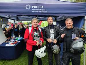 zdjęcie kolorowe: uczestnicy festynu przy namiocie profilaktycznym katowickiej komendy podczas pamiątkowego zdjęcia