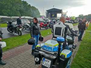 zdjęcie kolorowe: dwa policyjne motory na tle uczestników festynu „Pożegnanie lata z motocyklistami”