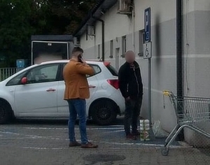 zdjęcie kolorowe: katowicki dzielnicowy w czasie wolnym od słuzby z zatrzymanym złodziejem sklepowym przed marketem spożywczym