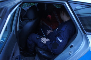 Zdjęcie kolorowe przedstawia umundurowanego policjanta realizującego doprowadzenie.