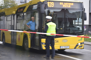 zdjęcie kolorowe: policjant katowickiej drogówki przy autobusie komunikacji miejskiej