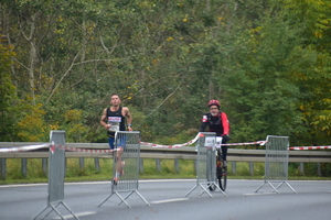 zdjęcie kolorowe: zawodnik na trasie biegu w towarzystwie rowerzysty