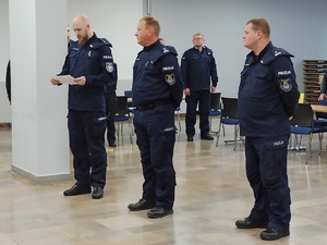 zdjęcie kolorowe: Zastępca Komendanta miejskiego Policji w Katowicach i Naczelnik Wydziału Sztab i policjant przedstawiający harmonogram dnia szkoleniowego