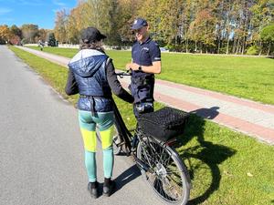 zdjęcie kolorowe: policjant rozmawiający z rowerzystką