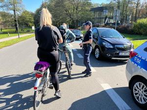 zdjęcie kolorowe: policjantka katowickiej komendy rozmawiająca z rowerzystami o bezpieczeństwie