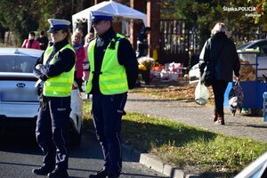 zdjęcie kolorowe: dwóch policjantów ruchu drogowego w rejonie cmentarza