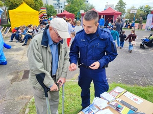 zdjęcie kolorowe: policjant rozmawiający na temat bezpieczeństwa z seniorem