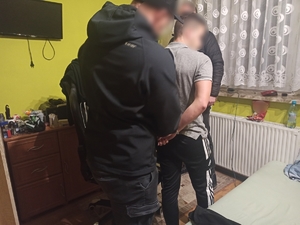 zdjęcie kolorowe: dwóch policjantów podczas zatrzymania pseudokibica w Rybniku