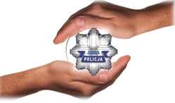 zdjęcie kolorowe: w dwie dłonie włożona policyjna odznaka z napisem Policja