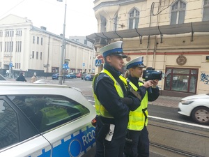zdjęcie kolorowe: policjantka i policjant na ulicy w Katowicach nadzorujący ruch drogowy