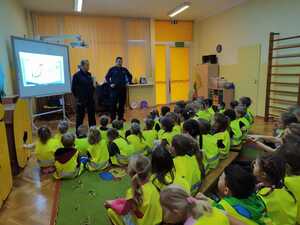 zdjęcie kolorowe: Młodszy aspirant Sylwia Michalak i młodszy  aspirant Szymon Rębisz dzielnicowi z komisariatu VII policji w Katowicach podczas zajęć o bezpieczeństwie z przedszkolakami