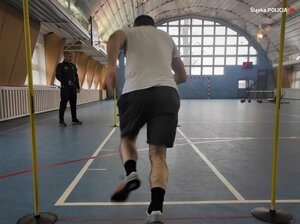 zdjęcie kolorowe: mężczyzna na hali sportowej przygotowujący się do biegu