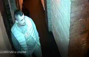 zdjęcie kolorowe: młody mężczyzna w korytarzu restauracji ubrany w jasne spodnie, bluzę z dresu i puchowy bezrękawnik