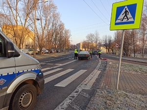 zdjęcie kolorowe: policyjny radiowóz i policjanci drogówki na miejscu potracenia kobiety przez samochód