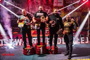 zdjęcie kolorowe: aspirant sztabowy na podium w  Mistrzostwa Niepodległej Polski w wyciskaniu sztangi leżąc z zawodnikami którzy zajęli drugie i trzecie miejsce