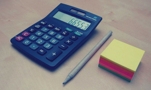 zdjęcie kolorowe: kalkulator, kartki i ołówek