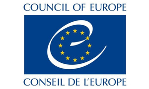 zdjęcie kolorowe: na błękitnym tle żółte gwiazdki symbolizujące Unię Europejską oraz napis w języku angielskim o treści Council of Europe