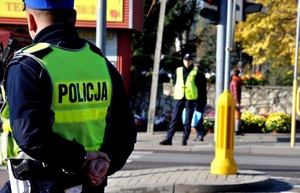 Zdjęcie kolorowe przedstawia policjanta na skrzyżowaniu.