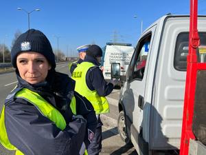 zdjęcie kolorowe: policjant katowickiej drogówki i funkcjonariusz WITD podczas kontroli drogowej