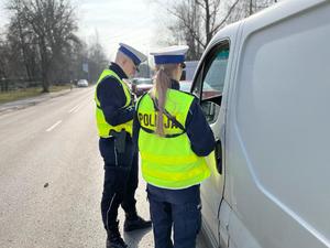 zdjęcie kolorowe: policjant i policjantka z katowickiej drogówki podczas rozmowy z kierującym furgonetką