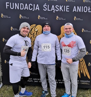 zdjęcie kolorowe: katowiccy dzielnicowi sierż. szt. Kamil Sierny, sierż. szt. Łukaszem Słabikiem oraz asp. szt. Arkadiusz Olejniczak na mecie charytatywnego biegu