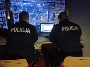 zdjęcie kolorowe: dwóch policjantów na stanowisku dowodzenia w katowickim Spodku