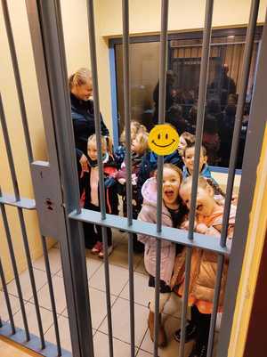 zdjęcie kolorowe: przedszkolaki zwiedzający policyjna celę z dzielnicową