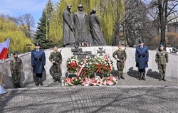 zdjęcie kolorowe: policjanci i żołnierze podczas warty honorowej przed pomnikiem upamiętniającym ofiary Zbrodni Katyńskiej