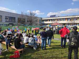 zdjęcie kolorowe: ogród Żłobka Miejskiego w Katowicach, gdzie rodzice, opiekunowie i dzieci słuchają prelekcji policjanta na temat bezpieczeństwa w ruchu drogowym