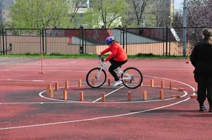 zdjęcie kolorowe: chłopak na rowerze wykonujący zadanie podczas Ogólnopolskiego Turnieju Bezpieczeństwa w Ruchu Drogowym