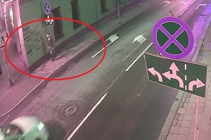 zdjęcie kolorowe: kadr z kamery monitoringu, która zarejestrowała mężczyznę idącego chodnikiem