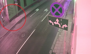 zdjęcie kolorowe: kadr z kamery monitoringu, która zarejestrowała mężczyznę idącego chodnikiem