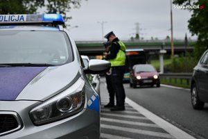 zdjęcie kolorowe: policjanci katowickiej drogówki podczas działań Prędkość kontrolujący samochód zatrzymany do kontroli drogowej
