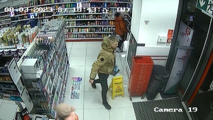 zdjęcie kolorowe: młody mężczyzna ubrany w jasnej kurtce i ciemnych spodniach w sklepie kosmetycznym