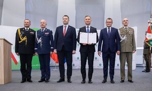 zdjęcie kolorowe:  Prezydenta RP Andrzeja Dudę podczas pamiątkowego zdjęcia po podpisaniu ustawy umożliwiającej powstanie Wyższej Szkoły Straży Granicznej, a także zmieniającej nazwy Wyższej Szkoły Policji w Szczytnie na Akademię Policji w Szczytnie oraz Szkoły Głównej Służby Pożarniczej na Akademię Pożarniczą.