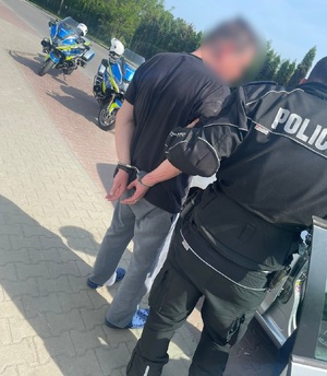 zdjęcie kolorowe: policjant drogówki z zatrzymanym nietrzeźwym kierującym