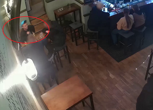 zdjęcie kolorowe: młody mężczyzna w niebieskiej czapce z daszkiem siedzący przy stoliku w restauracji