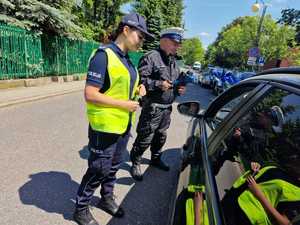 Zdjęcie kolorowe przedstawia policjantów Wydziału Ruchu Drogowego oraz Wydziału Prewencji Komendy Miejskiej Policji w Katowicach podczas działań w katowickiej strefie TEMPO 30.