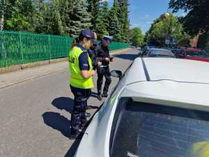 Zdjęcie kolorowe przedstawia policjantów Wydziału Ruchu Drogowego oraz Wydziału Prewencji Komendy Miejskiej Policji w Katowicach podczas kontroli drogowej.