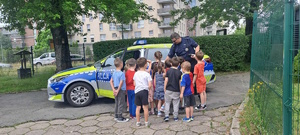 zdjęcie kolorowe: Mł. asp. Krystian Krukowski dzielnicowi z Komisariatu II Policji w Katowicach w ramach działań profilaktycznych „Bezpieczne wakacje 2023” spotkał się z dzieciakami