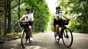 zdjęcie kolorowe: katowiccy policjanci podczas słuzby na rowerach patrolujący ulice i parki Katowic