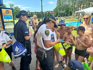 zdjęcie kolorowe: katowiccy policjanci i strażnicy miejscy podczas spotkania z dziećmi i młodzieżą na miejskim kąpielisku