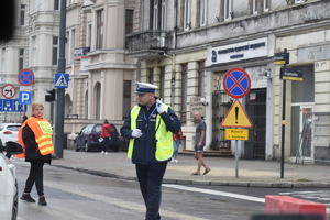 5- zdjęcie kolorowe: policjant ruchu drogowego pilnujący bezpieczeństwa w rejonie skrzyżowania