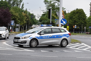 8 – zdjęcie kolorowe: policyjny radiowóz blokujący przejazd na skrzyżowaniu