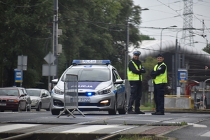 9 - zdjęcie kolorowe: policjant ruchu drogowego pilnujący bezpieczeństwa w rejonie skrzyżowania