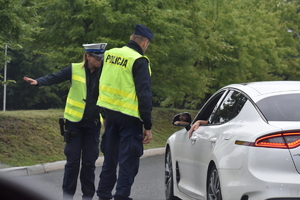 10 - zdjęcie kolorowe: policjanci na trasie rozmawiający z kierującym samochodem osobowym