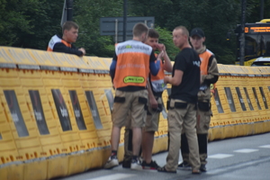 12 a - zdjęcie kolorowe: służby organizatora rozkładający zabezpieczenia na trasie